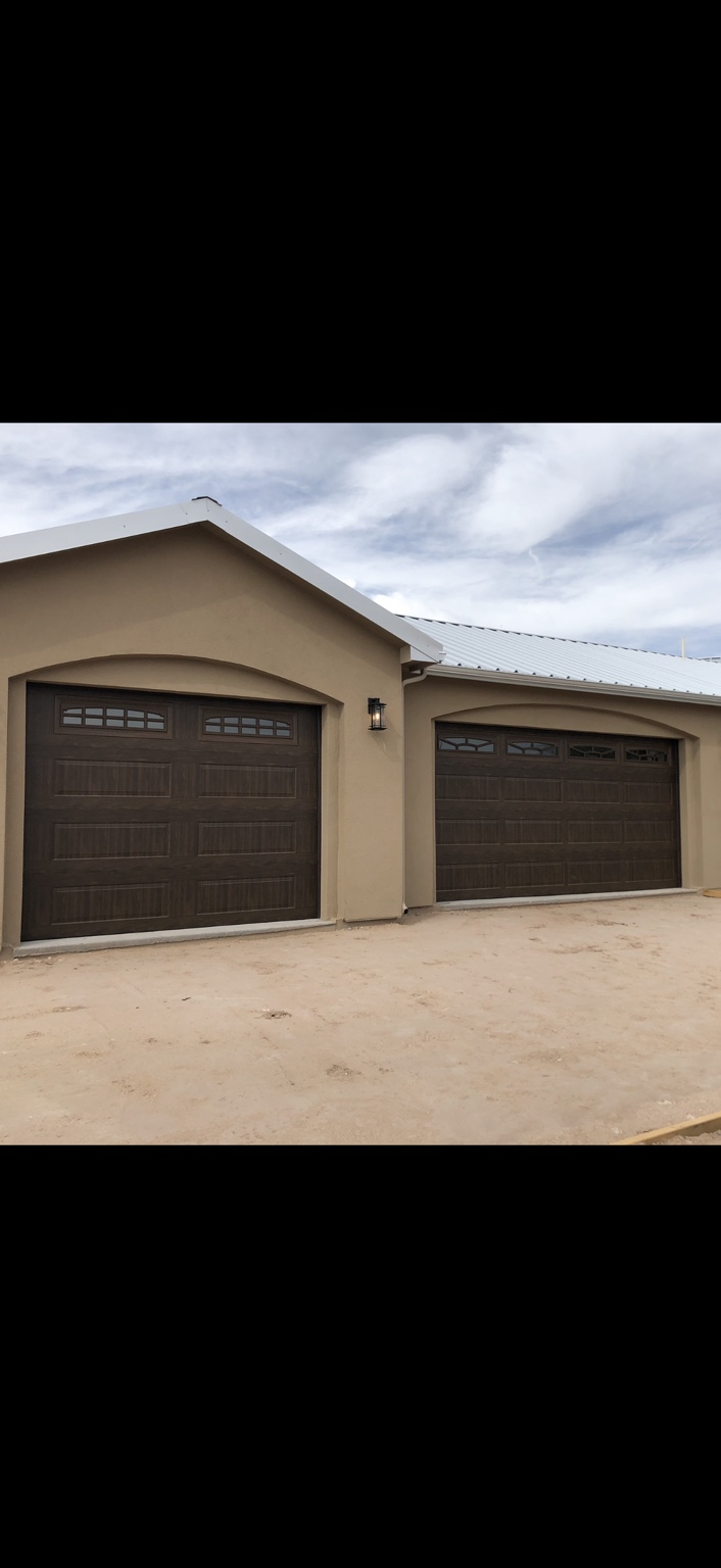Two brown carriage-style garage doors with decorative top windows