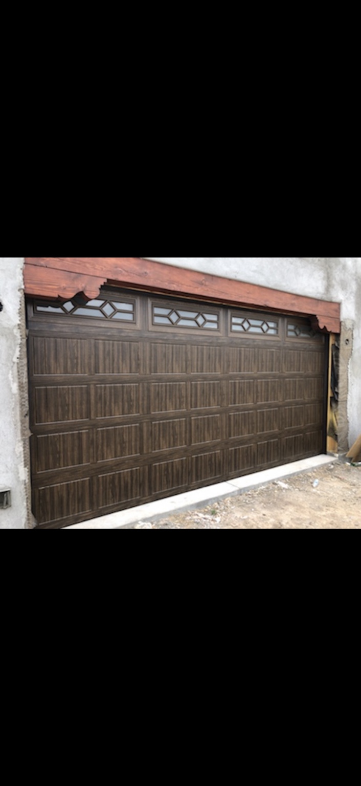 Brown garage door with wood-look panels and diamond-pattern decorative windows
